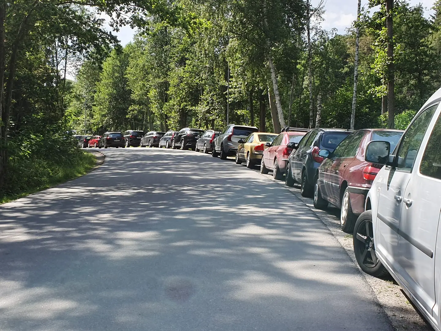 Parkerade bilar längs vägen mot friluftsområdet Eriksö i Vaxholm.