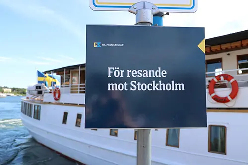 Skylt på kajen i Vaxholm om resa till Stockholm