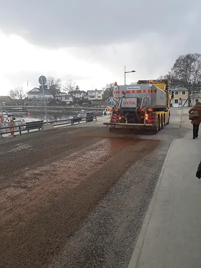 Bild på ett större vägfordon som jobbar med att dammbinda vägar i Vaxholm.