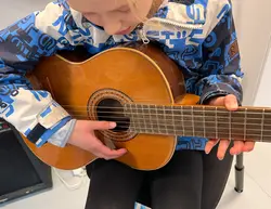 Flicka provar att spela gitarr